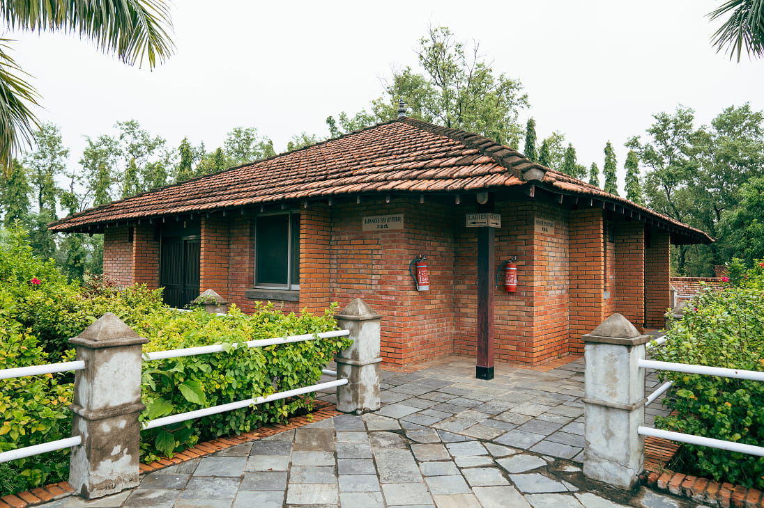 Red-brick guest building with a stone path at Hokke Hotel