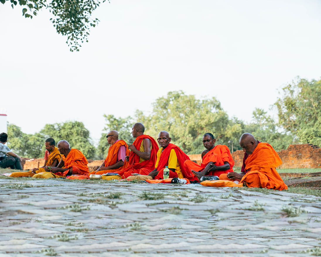 Monks in saffron robes seated in meditation in Lumbini