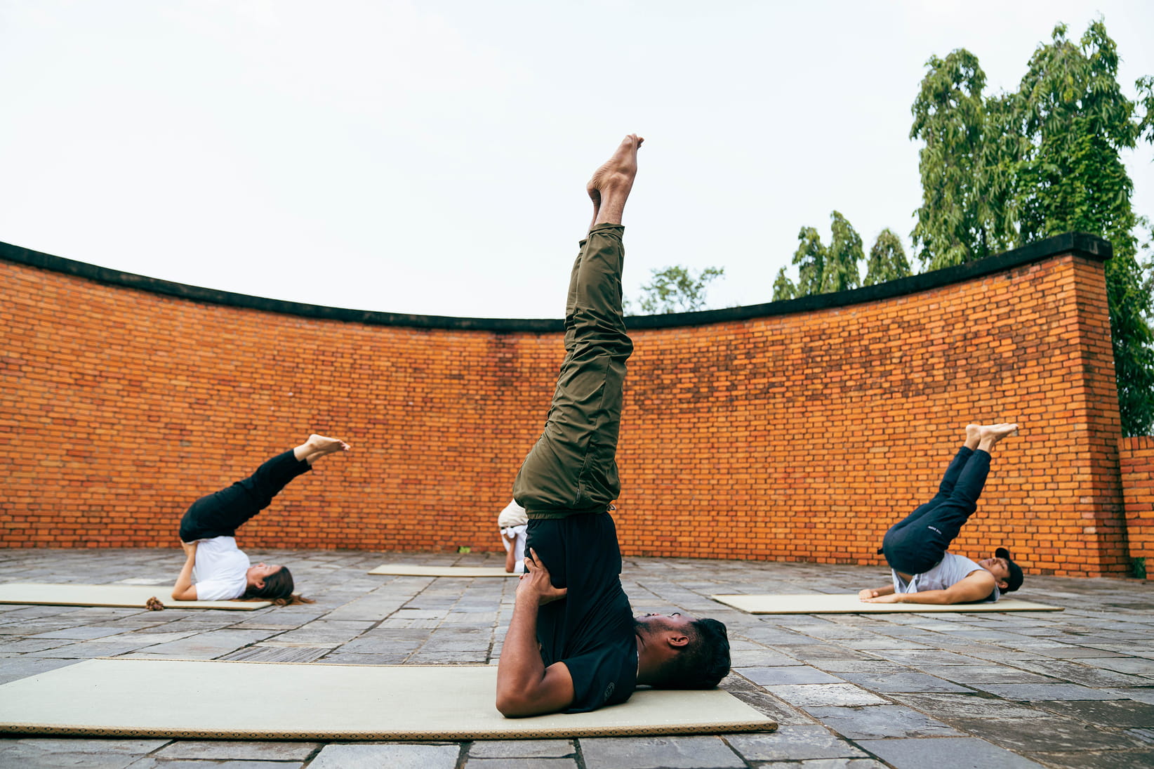 Guests in shoulder stand during morning yoga at Hokke Hotel